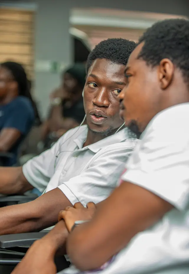 Two community members talking beside one another at the April meetup